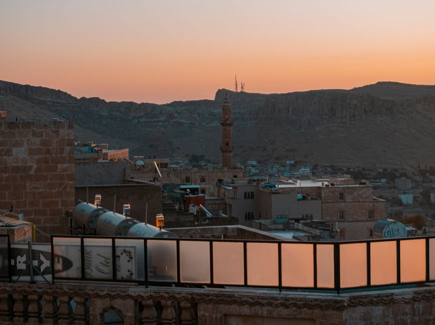 Minaret and stone rooftops at golden hour dusk