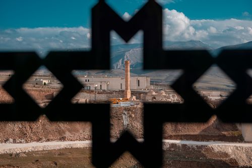 Free View of ancient Hasankeyf through geometric frame with mountains and sky backdrop. Stock Photo