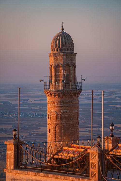 Photo of a Minaret against Agricultural Fields at Sunrise