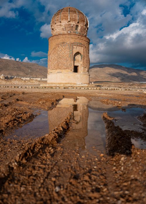 Free Zeynel Bey Tomb reflecting in muddy water with dramatic clouds in Hasankeyf, Turkey. Stock Photo