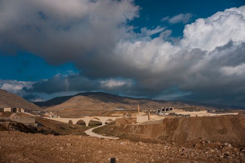 Free Dramatic landscape featuring Hasankeyf's ancient bridge under a captivating sky in Turkey. Stock Photo