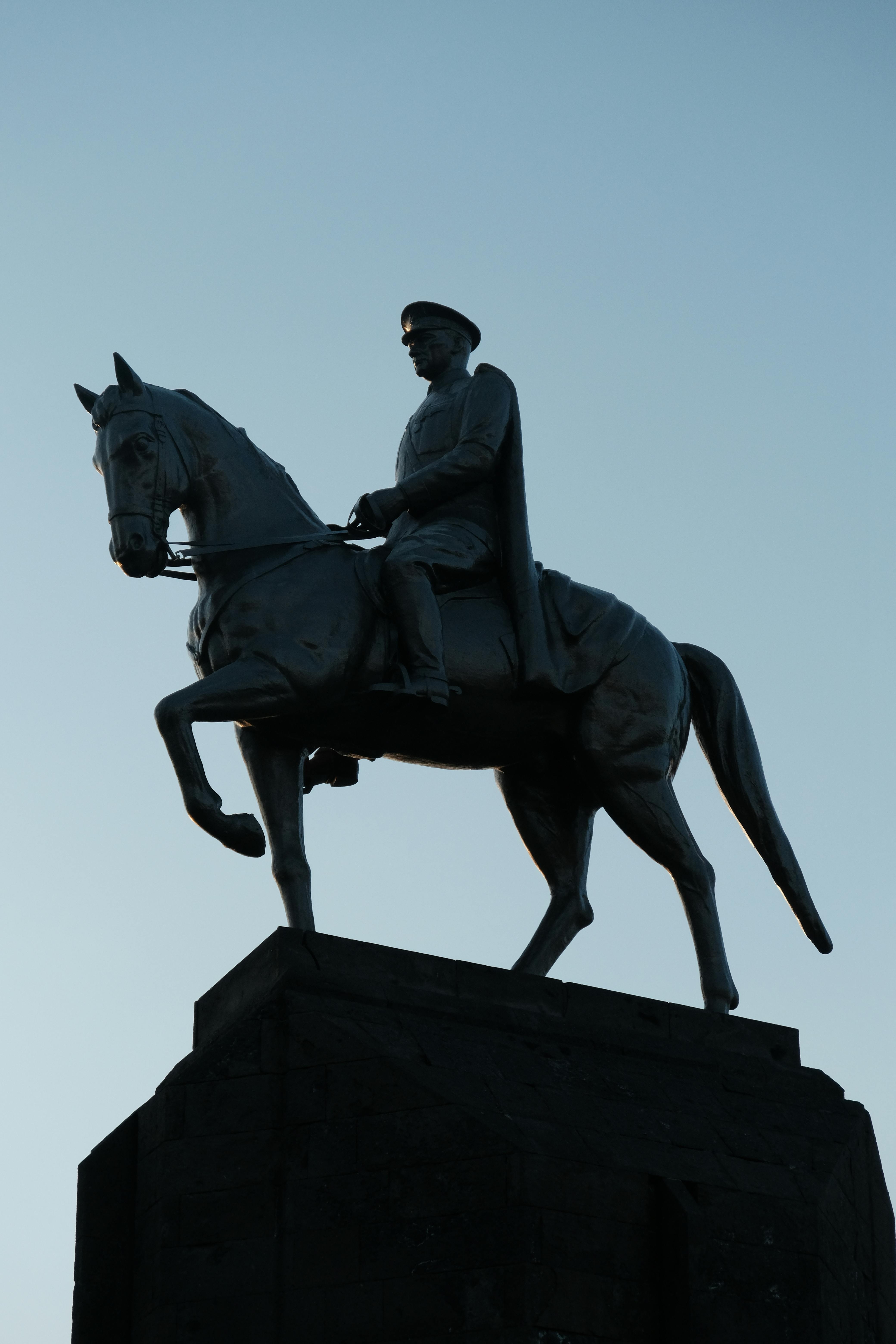 A striking silhouette of an equestrian statue captured at dusk, highlighting its historic significance.