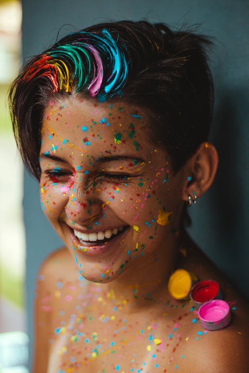 бесплатная Неглубокий фокус фото женщины, улыбающейся с краской для лица Стоковое фото