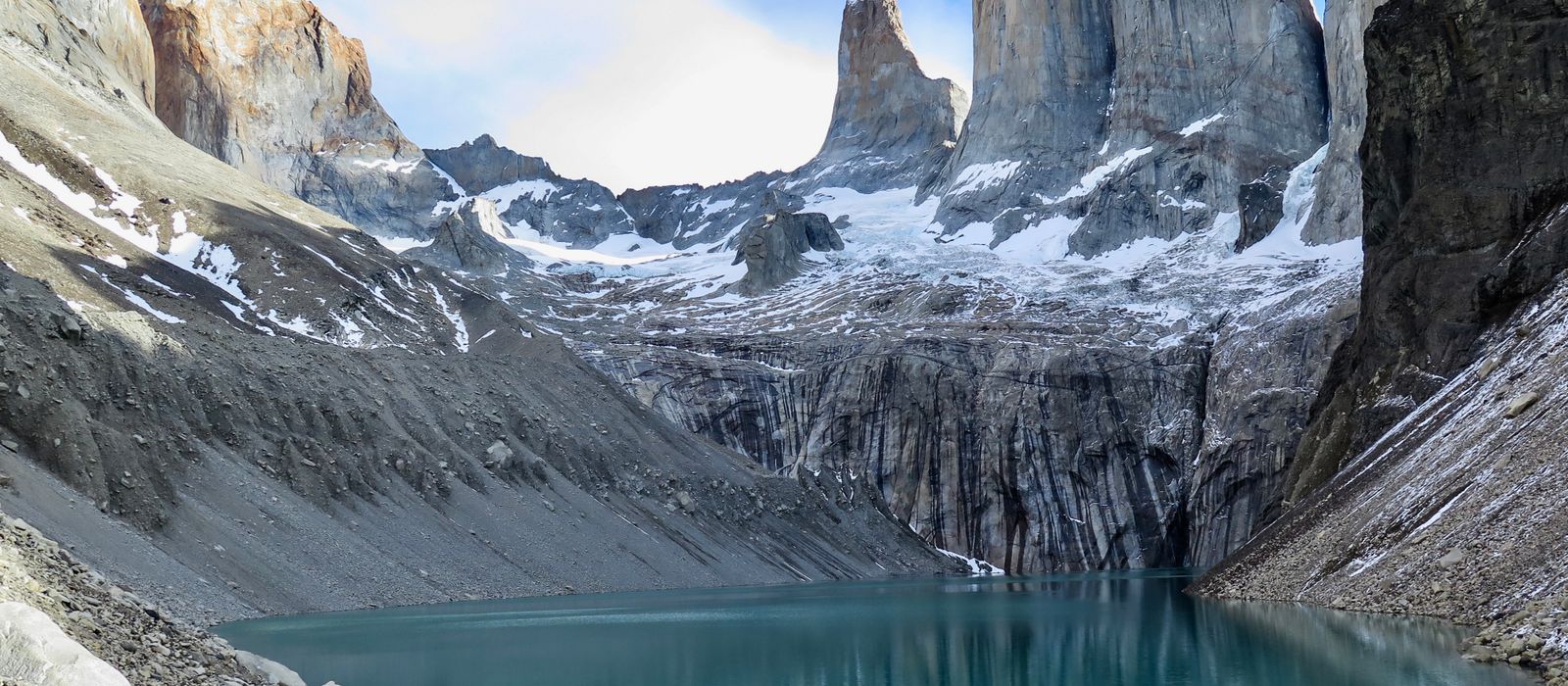 The granite towers of Torres del Paine rising above a turquoise glacial lake.