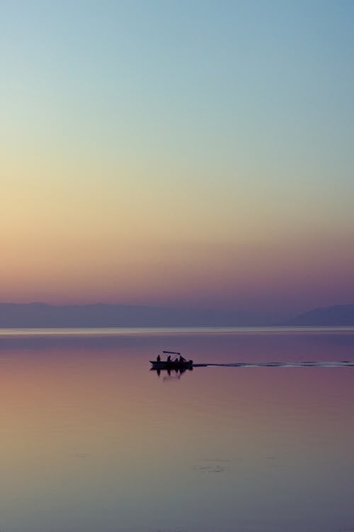 Silhouetted Boat on the Sea at Sunset