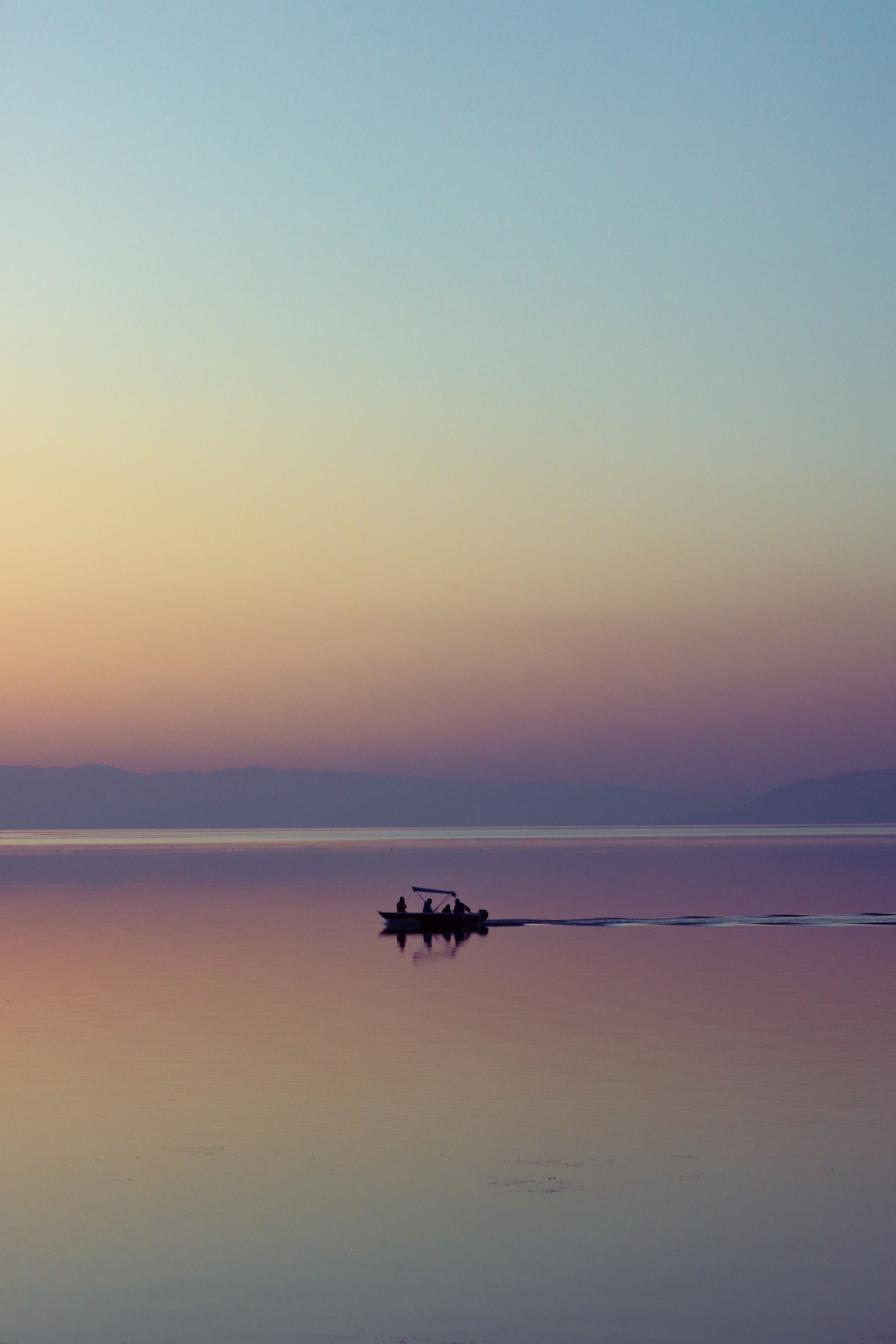 Silhouetted Boat on the Sea at Sunset · Free Stock Photo