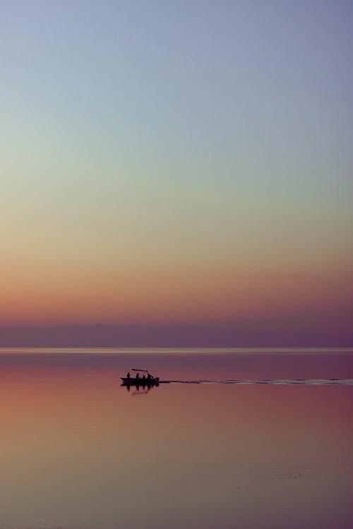 Silhouetted Boat on the Sea at Sunset
