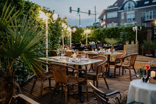 Cozy outdoor restaurant terrace with ambient lighting and elegant table setup.