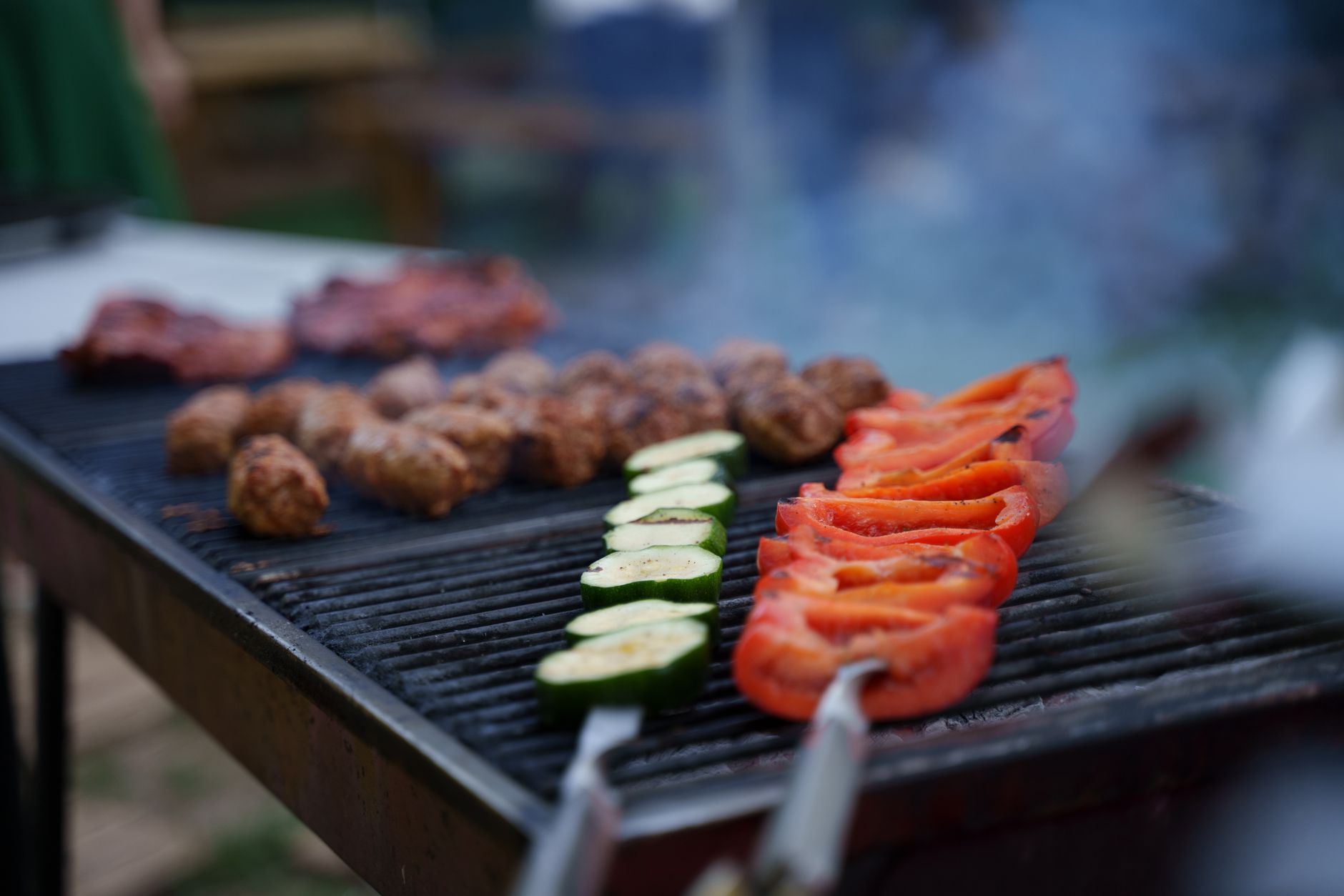Vegetables sizzling on a hot grill with visible char marks