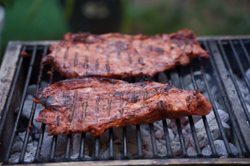 Free Close-up of juicy beef steaks grilling over hot charcoal on an outdoor barbecue grill. Stock Photo