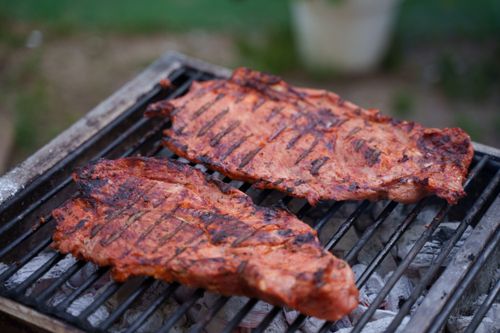 Free Close-up of flavorful grilled steaks sizzling on an outdoor barbecue grill. Stock Photo