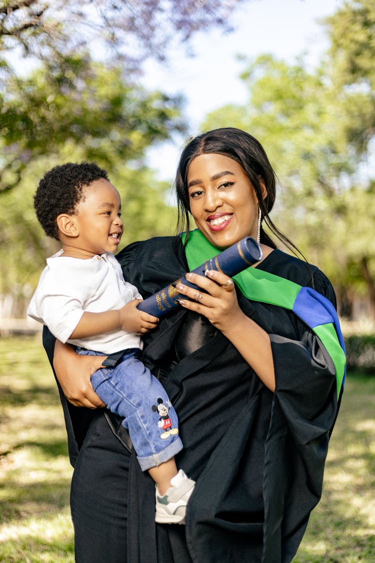 A Mother Holding A Child And A Diploma