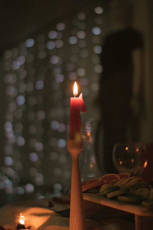 Free A serene candlelit evening scene with a glowing flame and soft background bokeh effect. Stock Photo