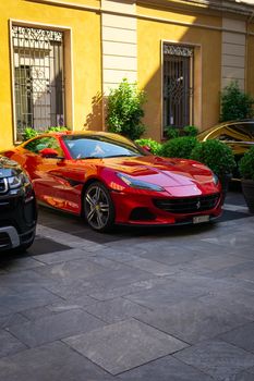 A striking red sports car parked stylishly in an elegant urban environment.