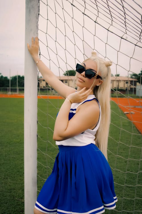 Blonde Model in Sunglasses and Skirt on Soccer Stadium