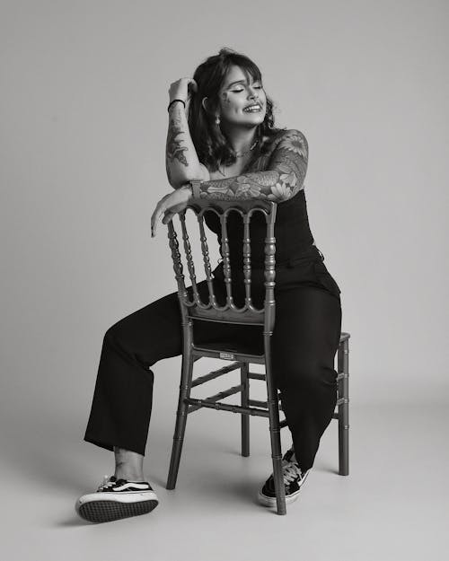 A Tattooed Woman Sitting on a Chair