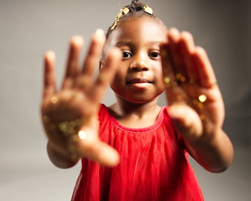 Small Child Showing Hands Covered in Golden Glitter