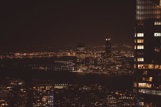 Explore the captivating skyline of New York City by night, featuring the Hudson River.