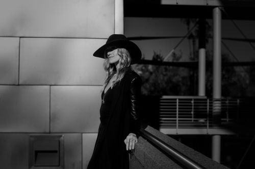Free Fashionable woman posing outdoors in black and white with a stylish hat and leather jacket. Stock Photo