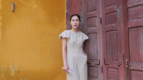 Model in Elegant Onesie Posing by Old Wooden Door