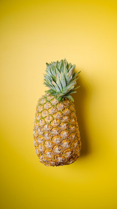 A Pineapple Lying on Yellow Background 