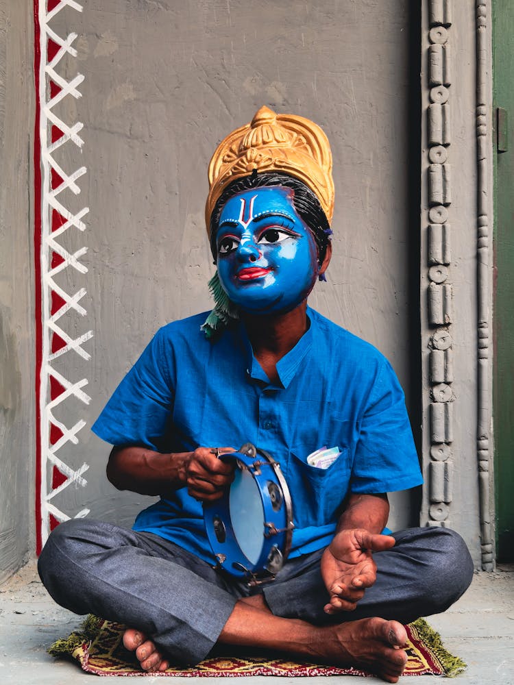 Man In A Costume Of A Hindu Deity Sitting On The Floor