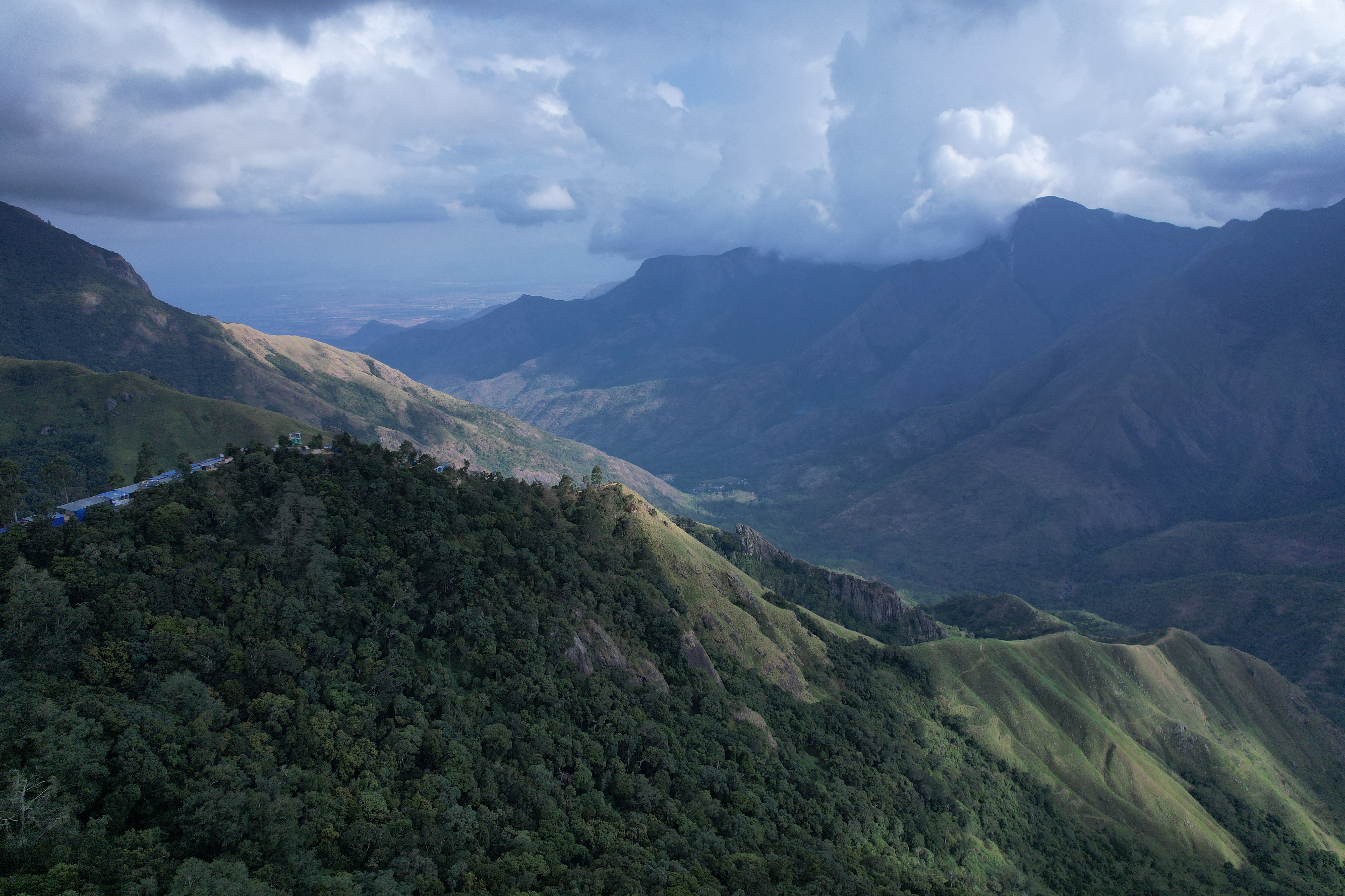 Breathtaking view of lush mountains and dramatic skies in Kochi, India.