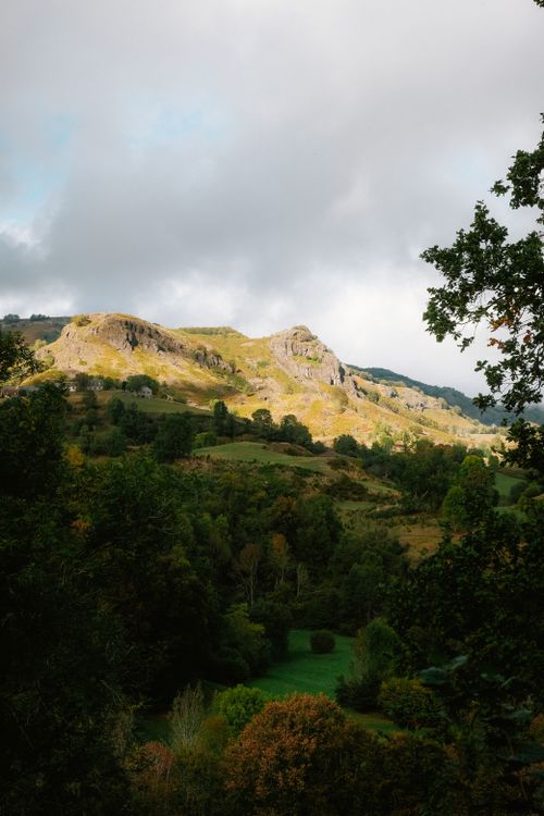 Free Stunning aerial photo capturing lush green hills and dramatic clouds. Stock Photo