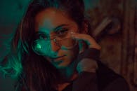 在昏暗的环境中，一位戴着时尚眼镜的女性的迷人肖像