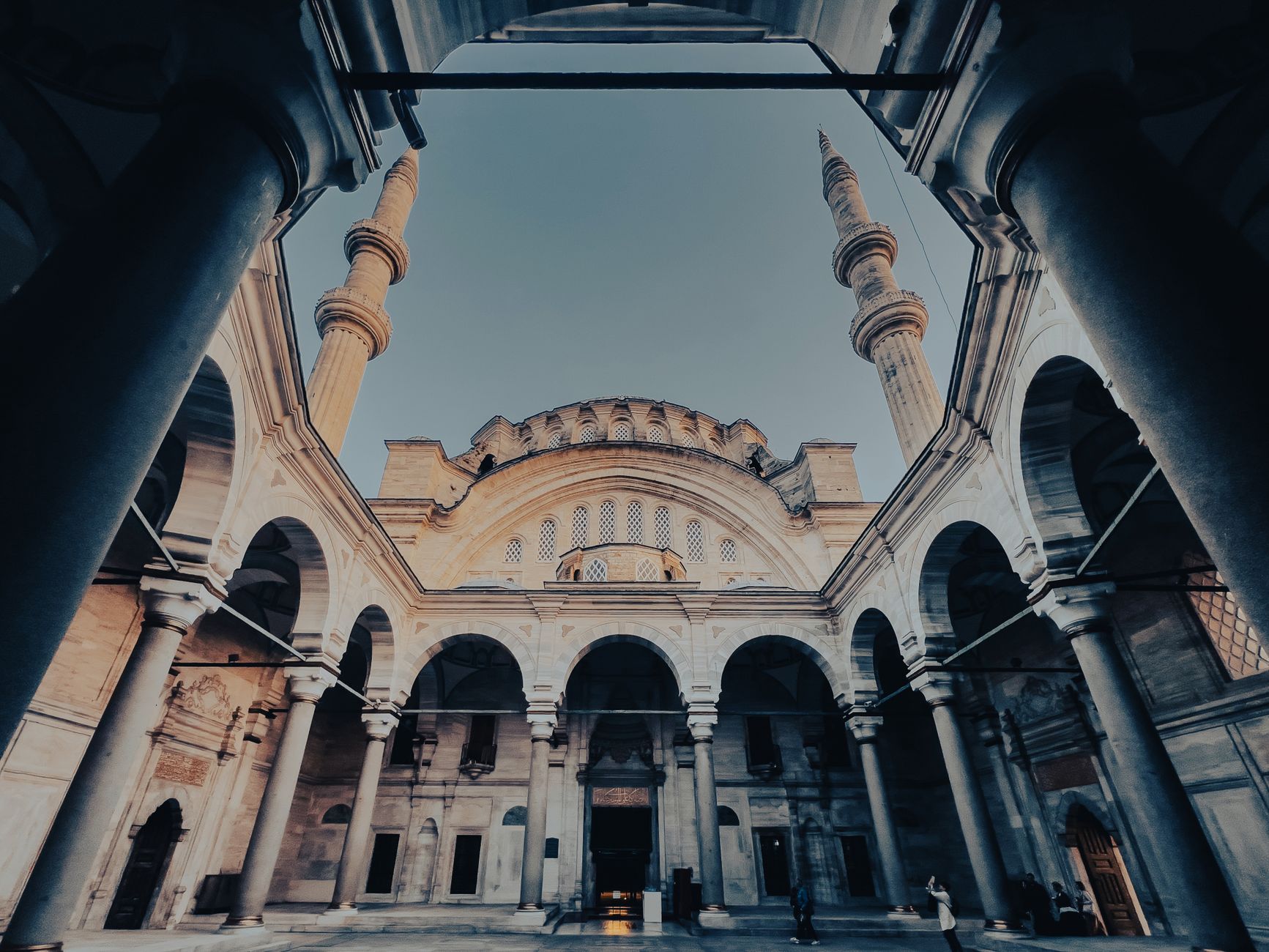 View of Nurosmaniye Mosque courtyard with minarets on a clear day in Istanbul, Turkey.