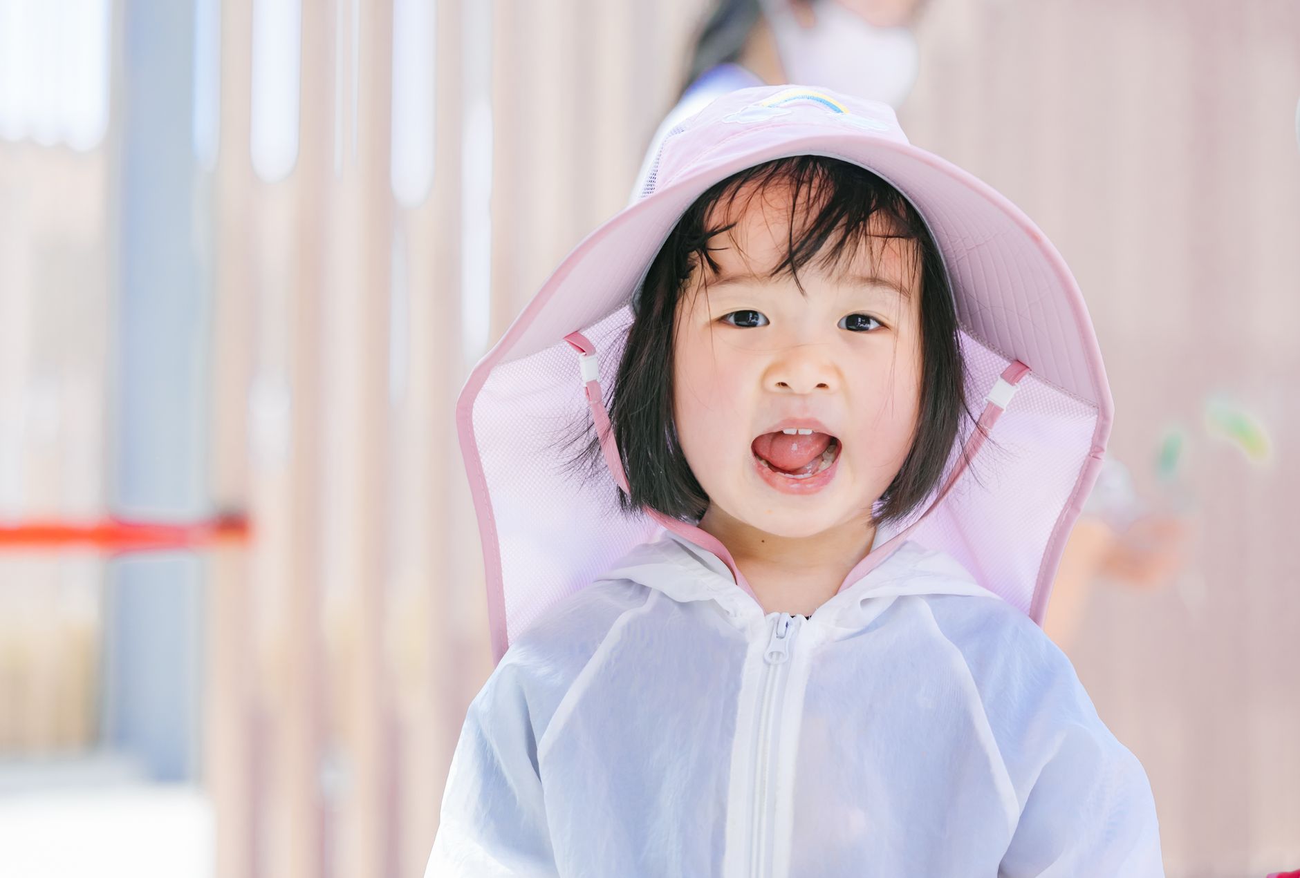 A joyful young child wearing a sunhat, enjoying the sunny day outdoors, emanating innocence.