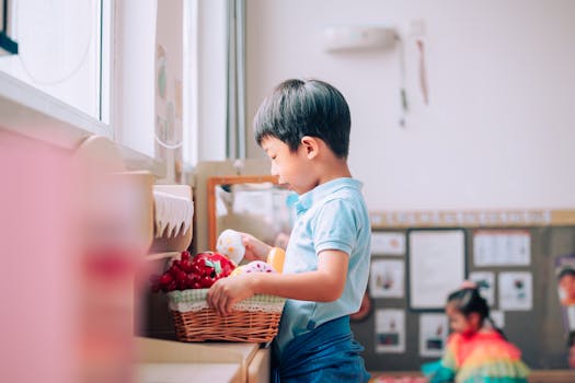 Asian boy learning in a colorful classroom setting with educational toys.
