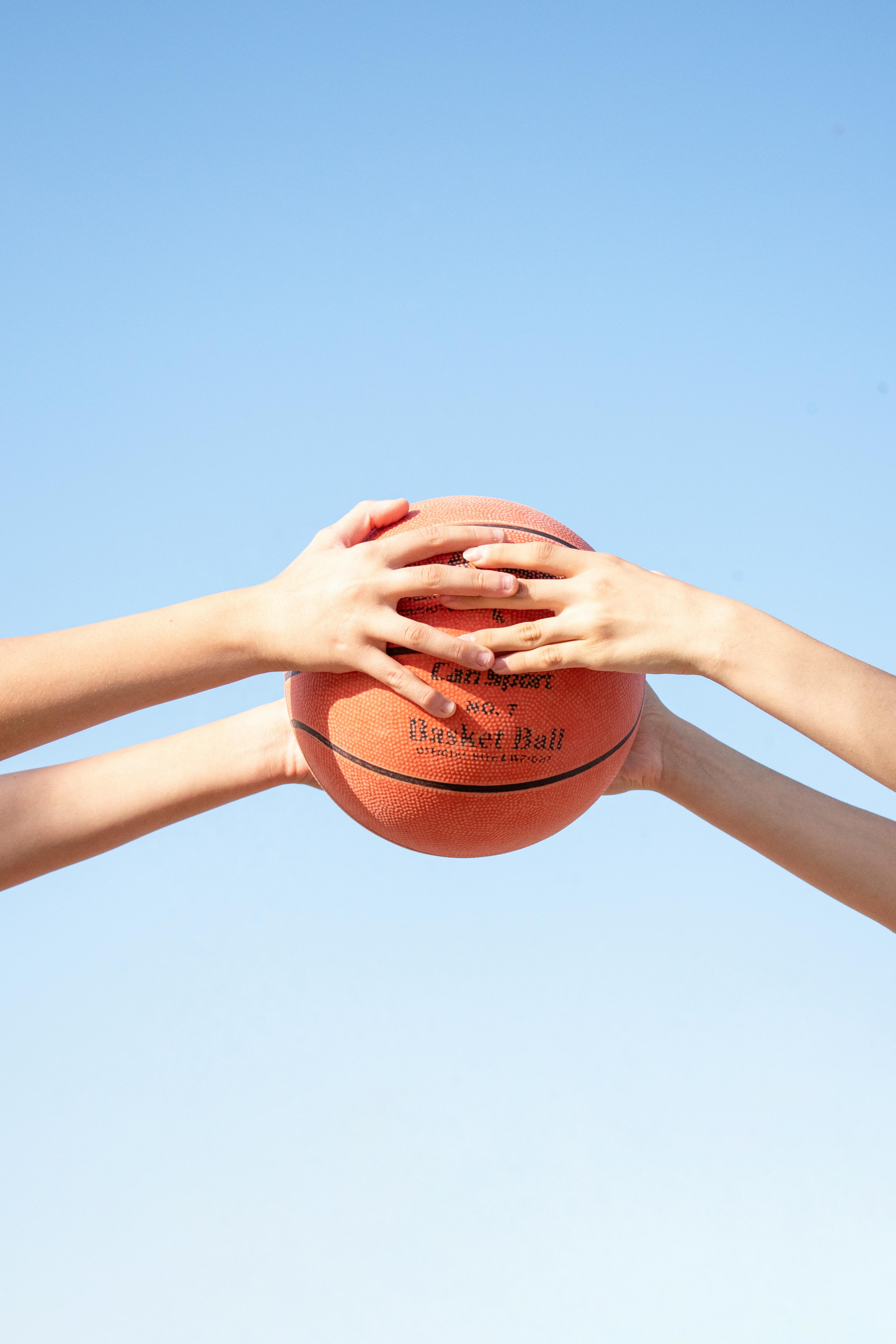 people holding basketball ball