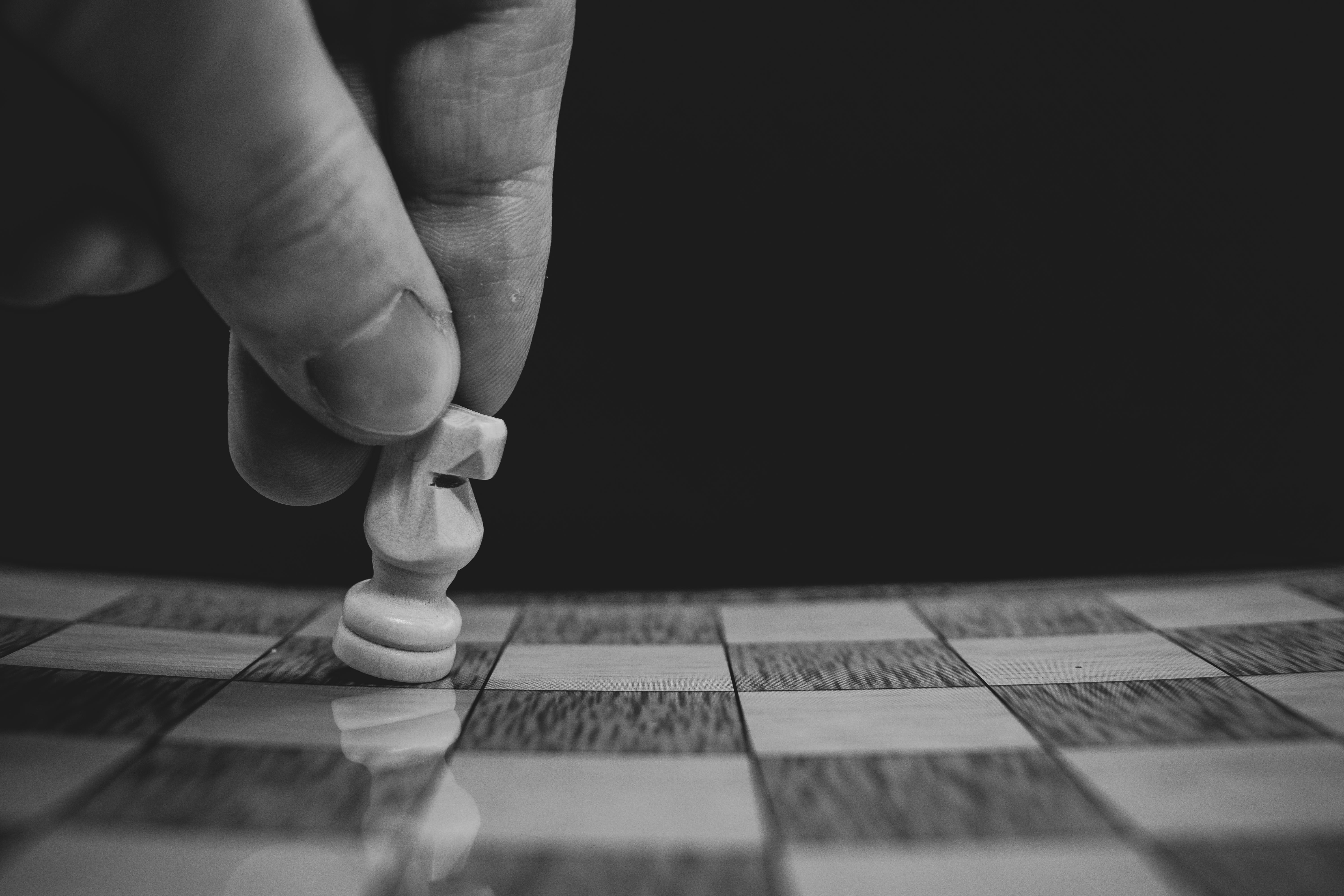 close up of a person moving a pawn on a chessboard