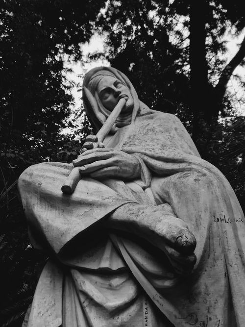 Free Captivating black and white image of a statue playing the flute, surrounded by nature in Algiers. Stock Photo
