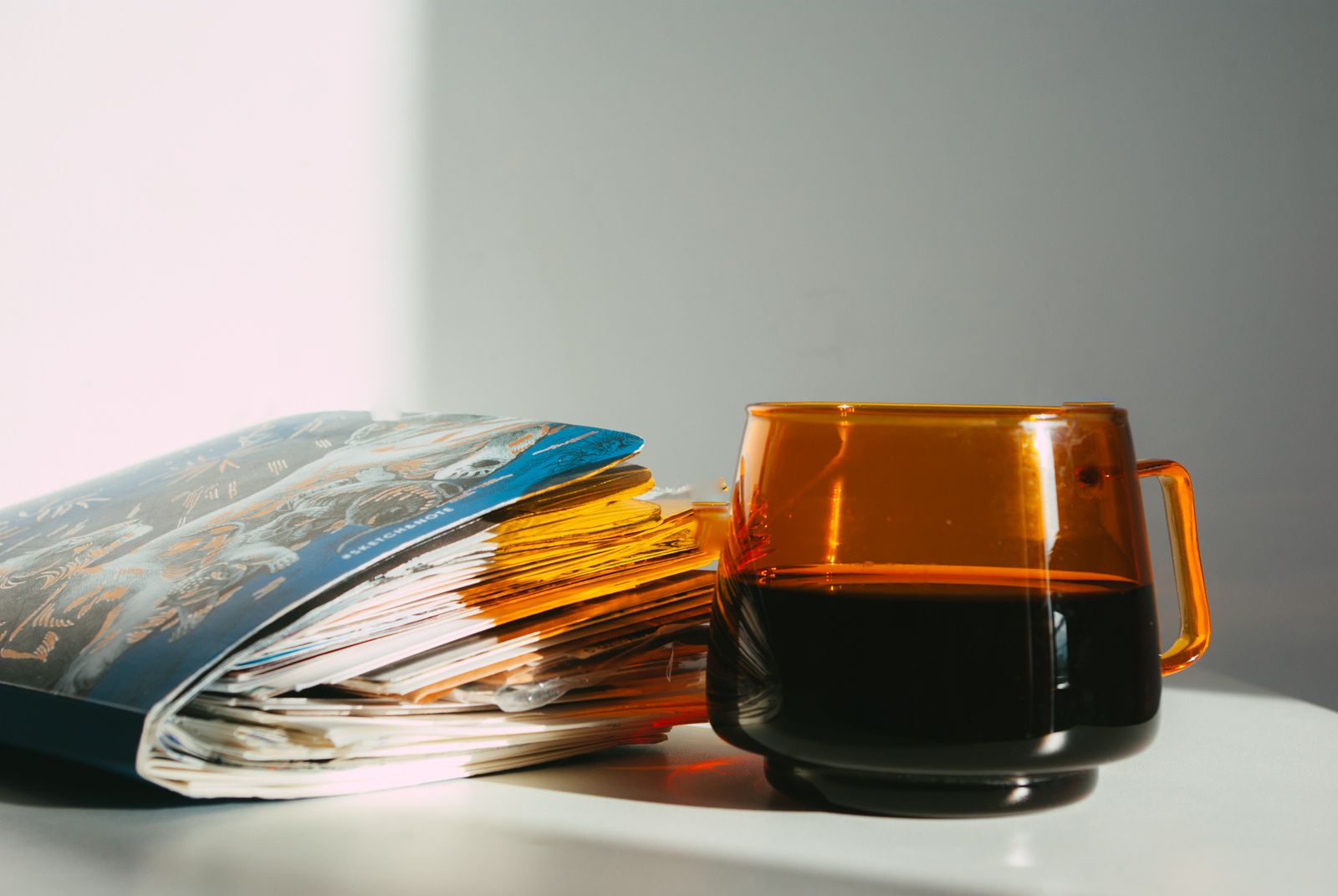 An amber cup beside a well-used notebook