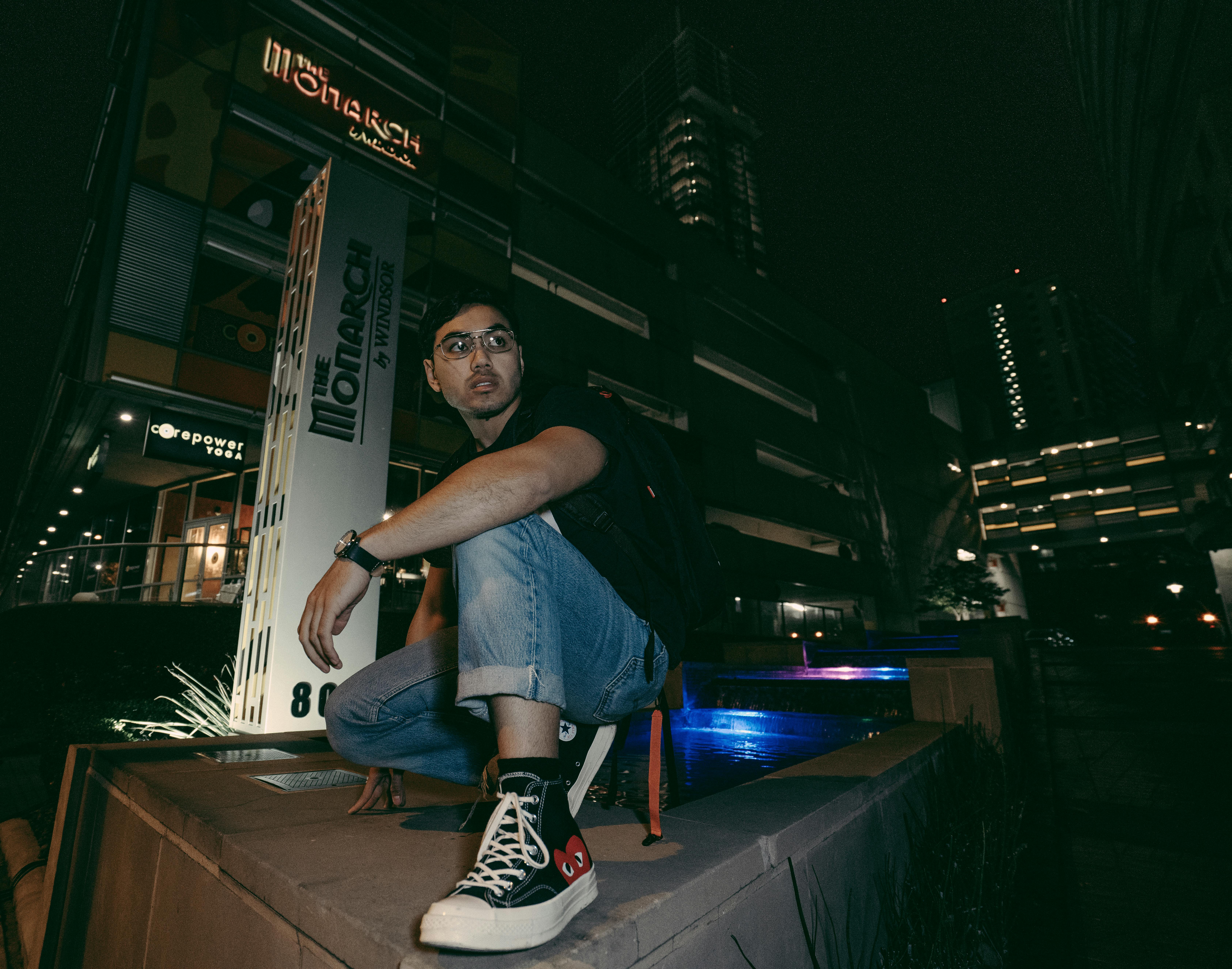 一名男子在夜晚灯火通明的城市环境中摆姿势