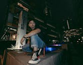 一名男子在夜晚灯火通明的城市环境中摆姿势