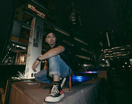 一名男子在夜晚灯火通明的城市环境中摆姿势