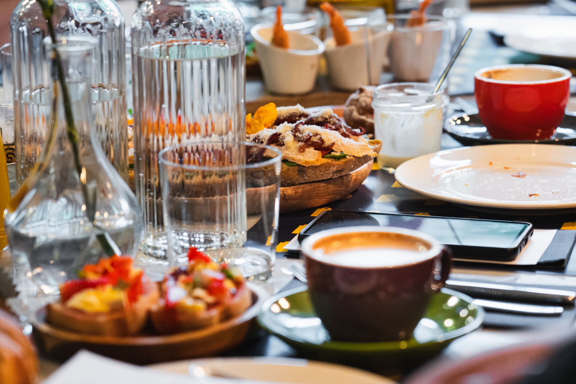 Colorful breakfast table featuring coffee, pastries, and various dishes, perfect for food lovers.