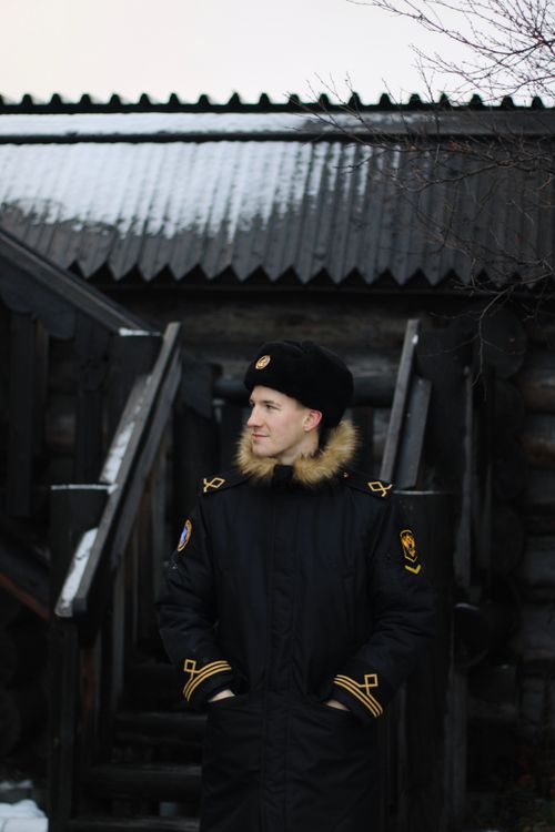 Free Man in a fur-lined coat and hat standing outdoors in winter, Murmansk. Stock Photo