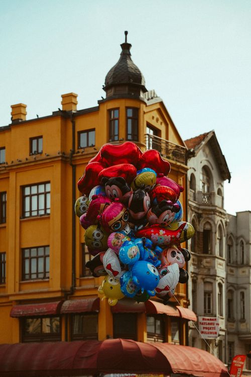 Free Vibrant balloons float in front of historic Ankara architecture. Stock Photo