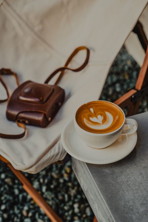 Free A stylish cappuccino and leather bag setup at a café in Ankara, Türkiye. Stock Photo