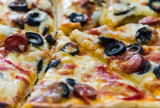 Delicious close-up of pepperoni pizza with melted cheese and black olives.