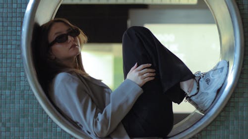 Young Woman Sitting in a Circular Window 