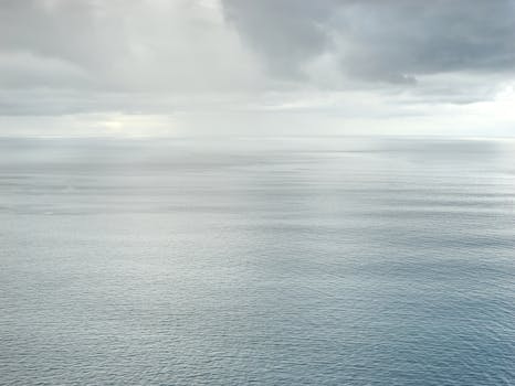 A serene aerial view of the ocean with a cloudy sky, perfect for tranquil scenes.