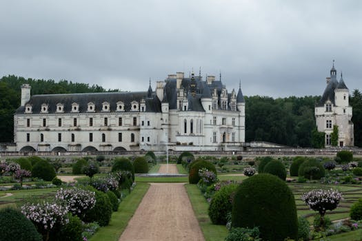 A stunning view of the Château de Chenonceau surrounded by vibrant gardens in Chenonceaux, France.