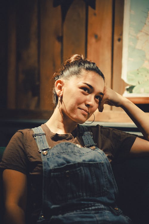 Young Woman Posing in Blue Denim Overalls and Brown T-Shirt