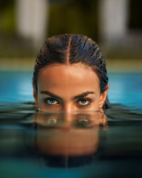 Photo of a Woman Emerging from the Water in a Swimming Pool