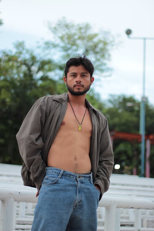 Shirtless Model in an Gray Jacket and Jeans in a Park